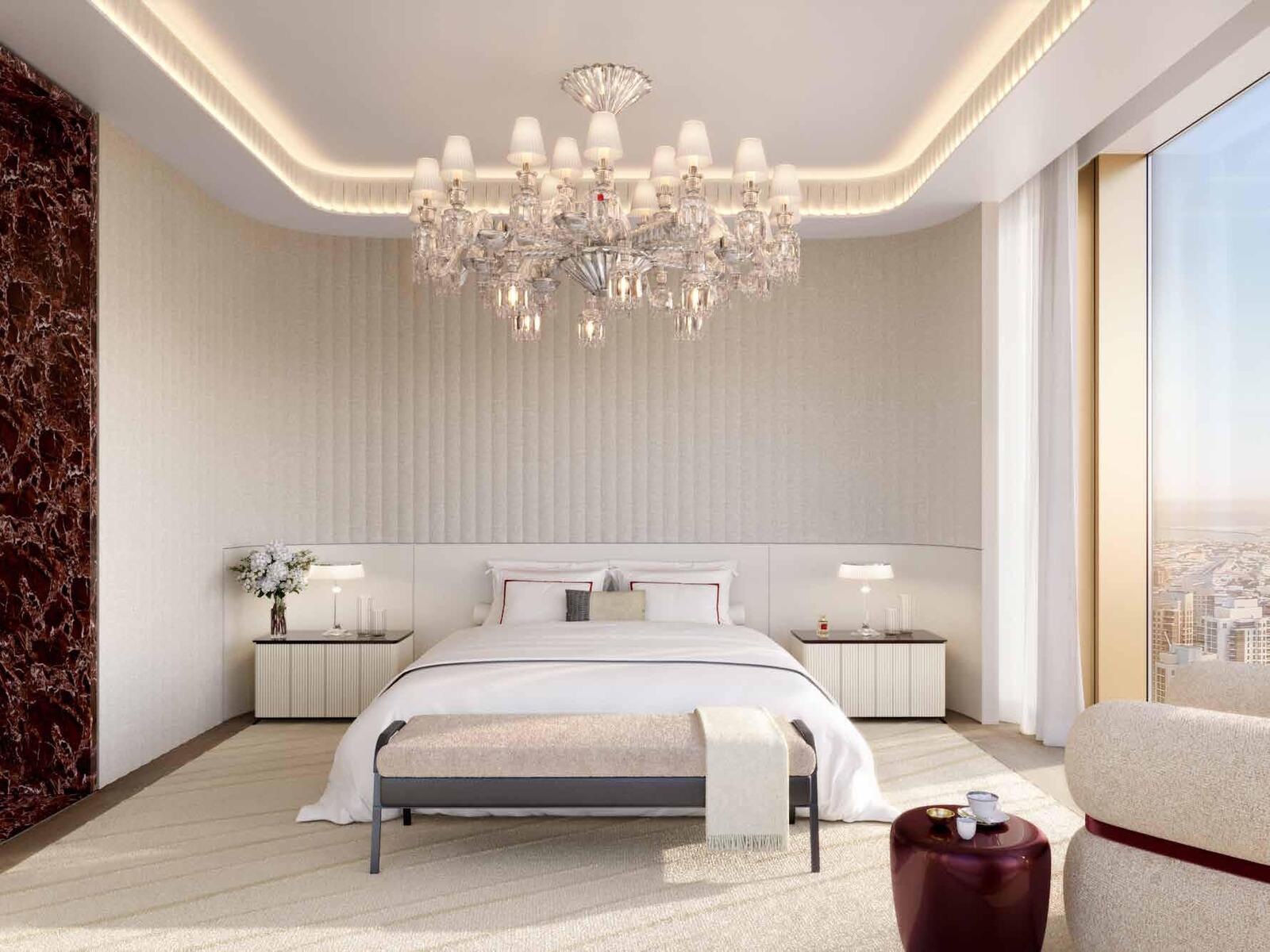 a bedroom with a large bed and a chandelier